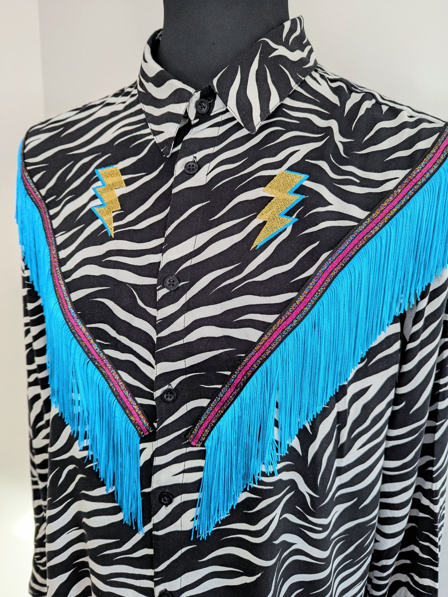 rodeo style western fringe shirt with embroidered gold lighting bolts and turquoise tassel trim
