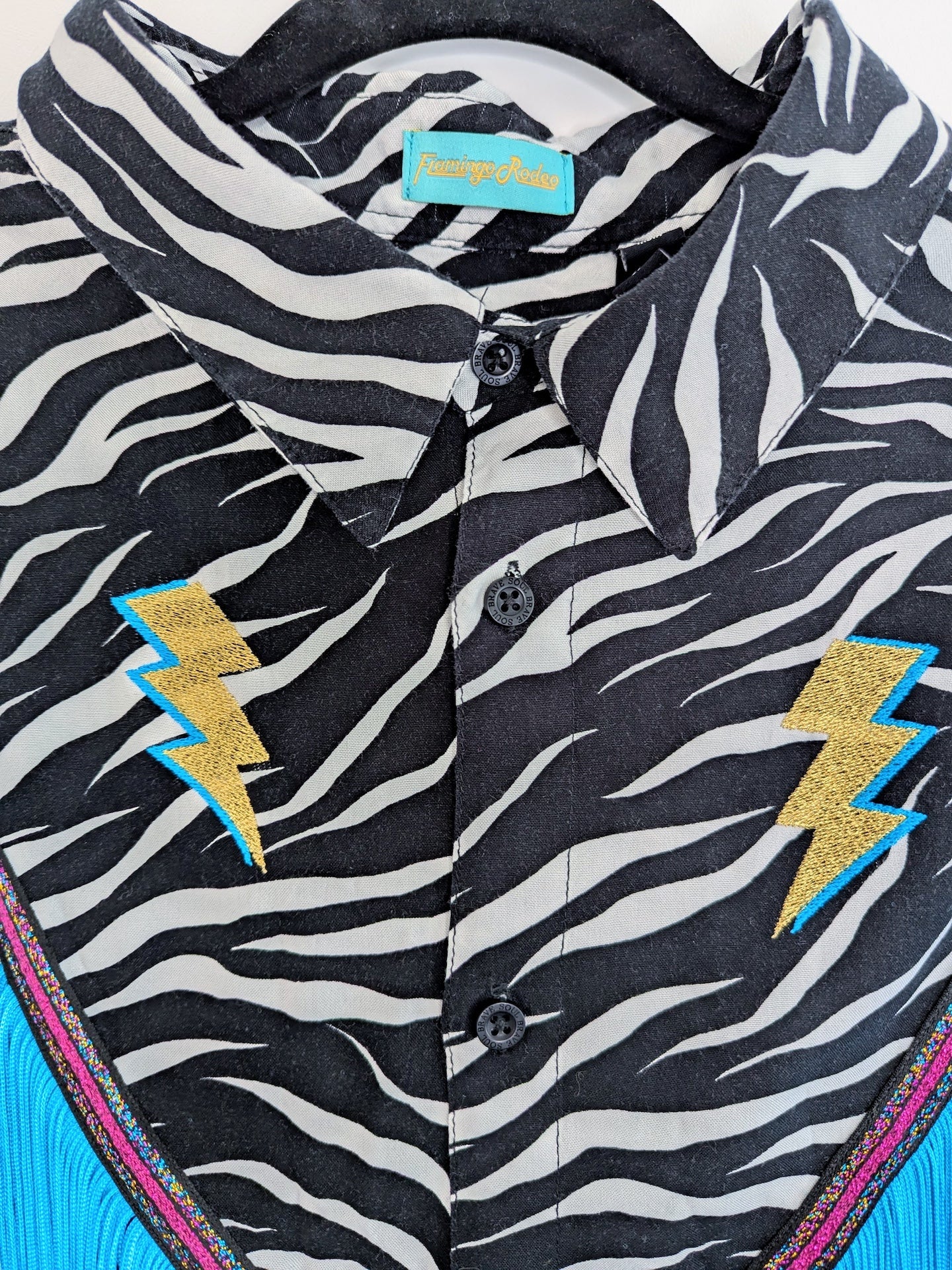Button-up shirt with zebra pattern and metallic gold sparkly lightning bolt embroidered designs 