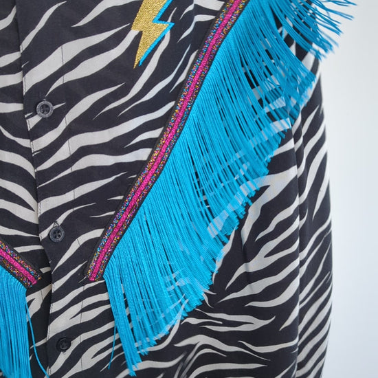 western rodeo style fringe shirt being shaken to show showing the movement of the tassel fringe