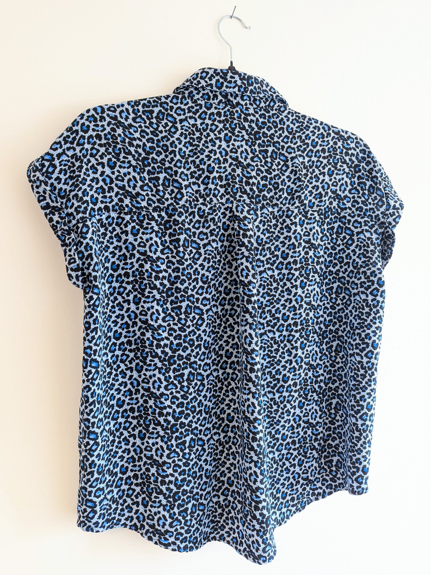 the back of a pale blue leopard print sleeveless shirt 