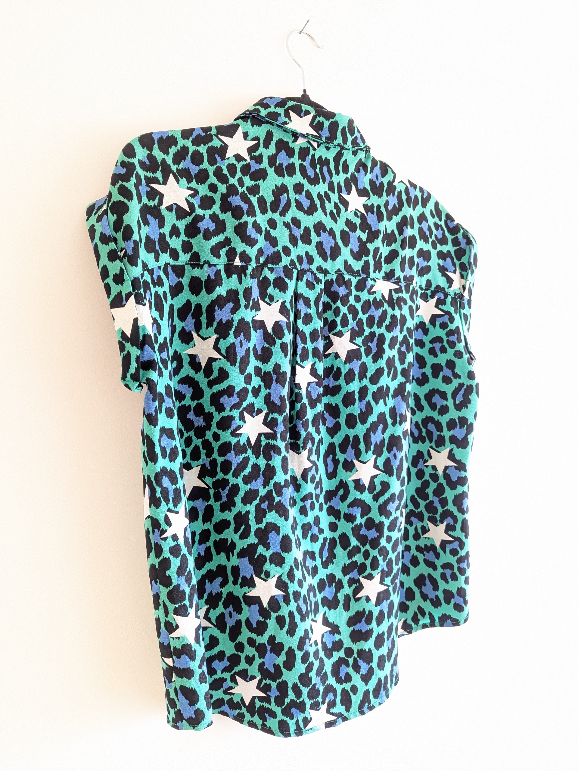 the back of a sleeveless green and blue leopard print shirt with white stars