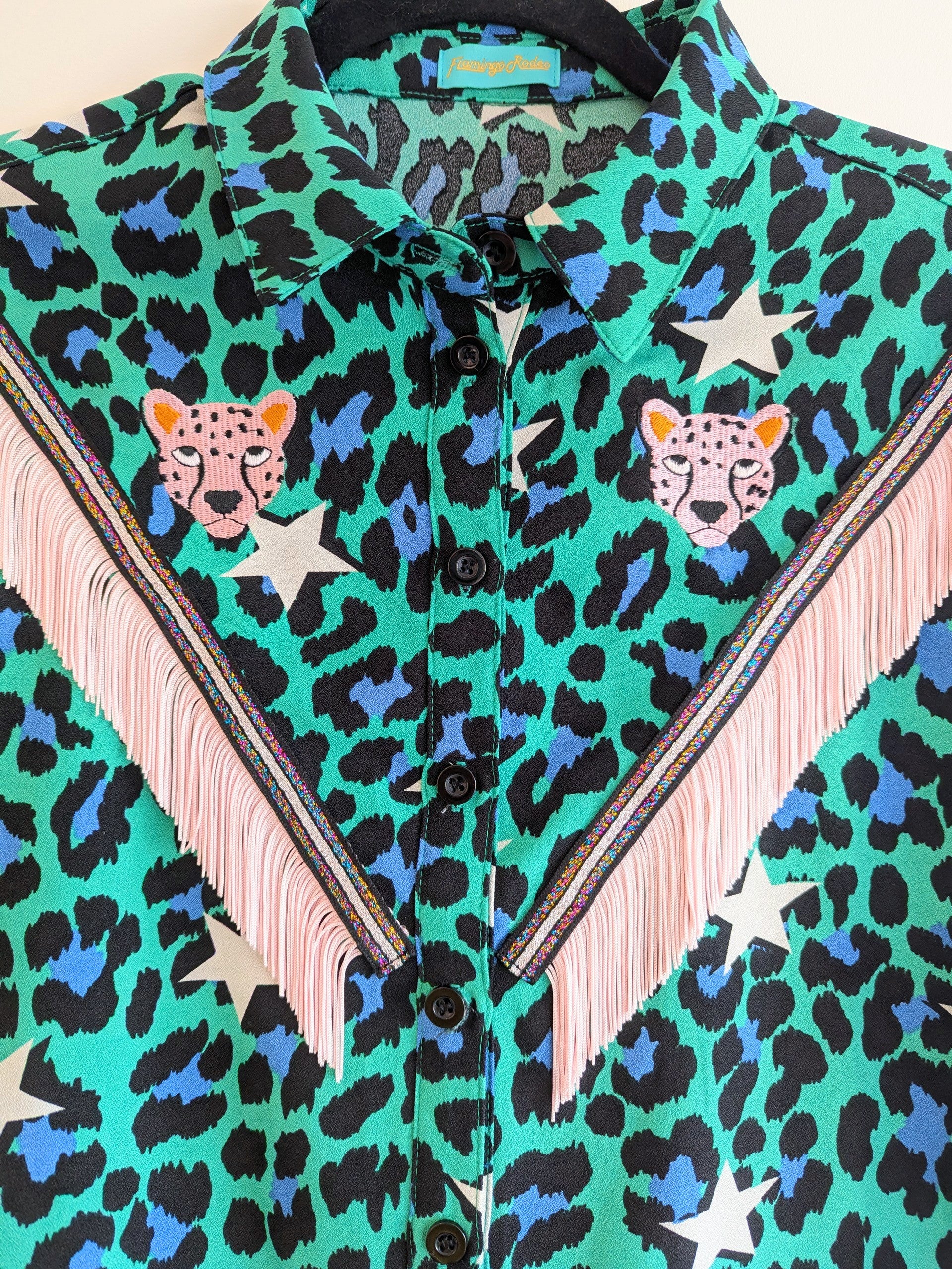 Green shirt with leopard print and star patterns. It has embroidery pink leopards and western style pale pink fringe trim added.